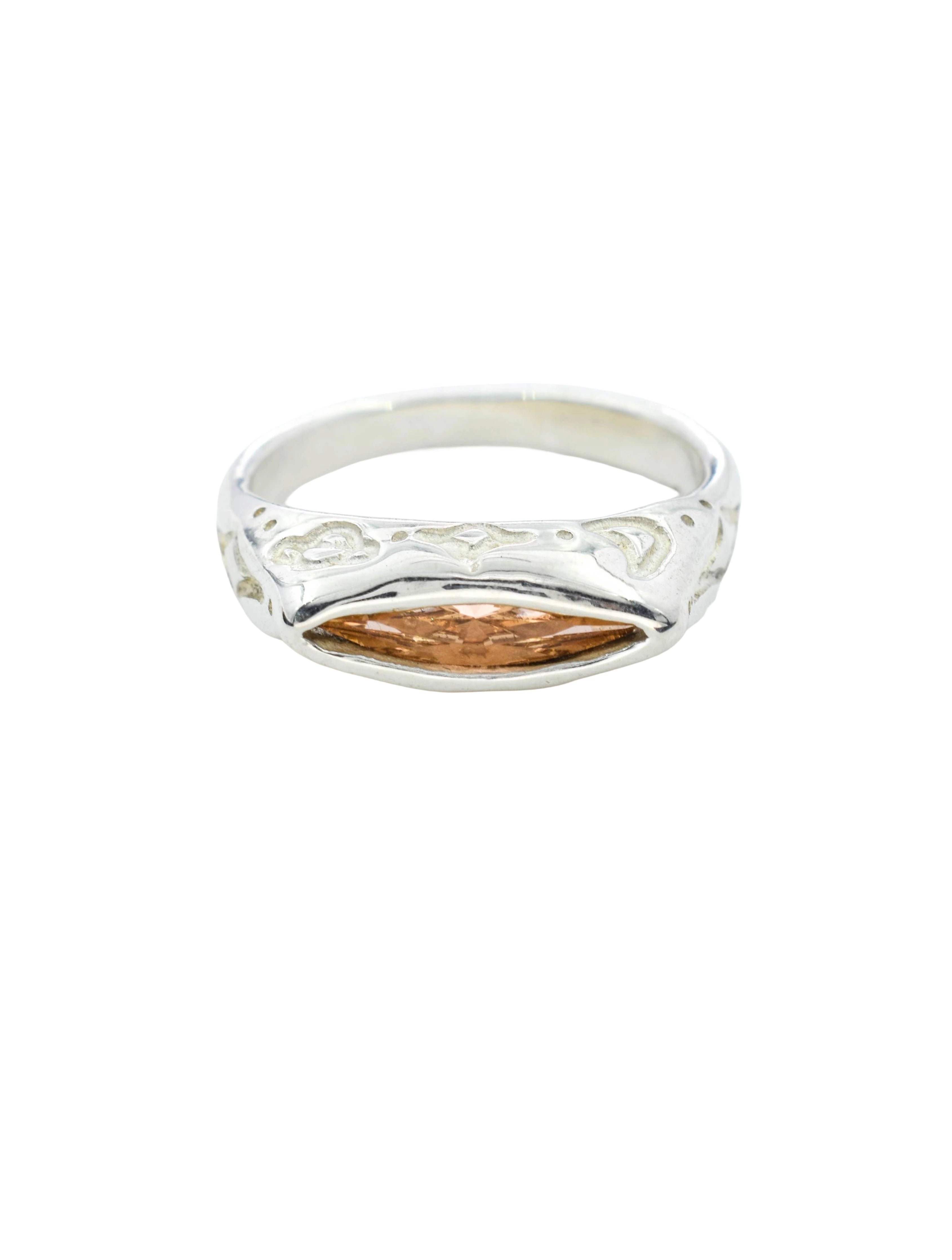 Silver ring with intricate design on a white background