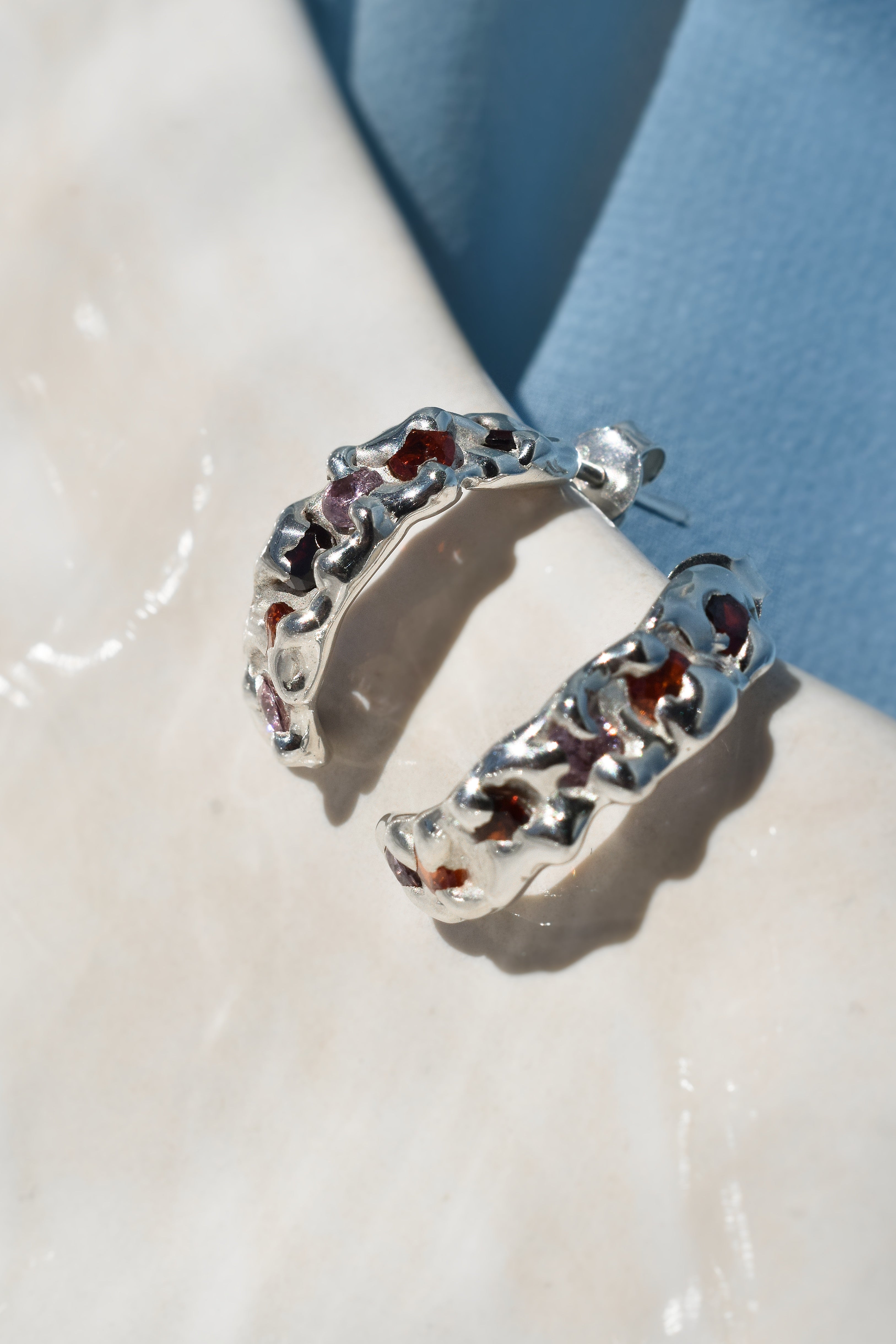 Sterling silver molten textured hoop earrings with red, orange & pink cz crystals