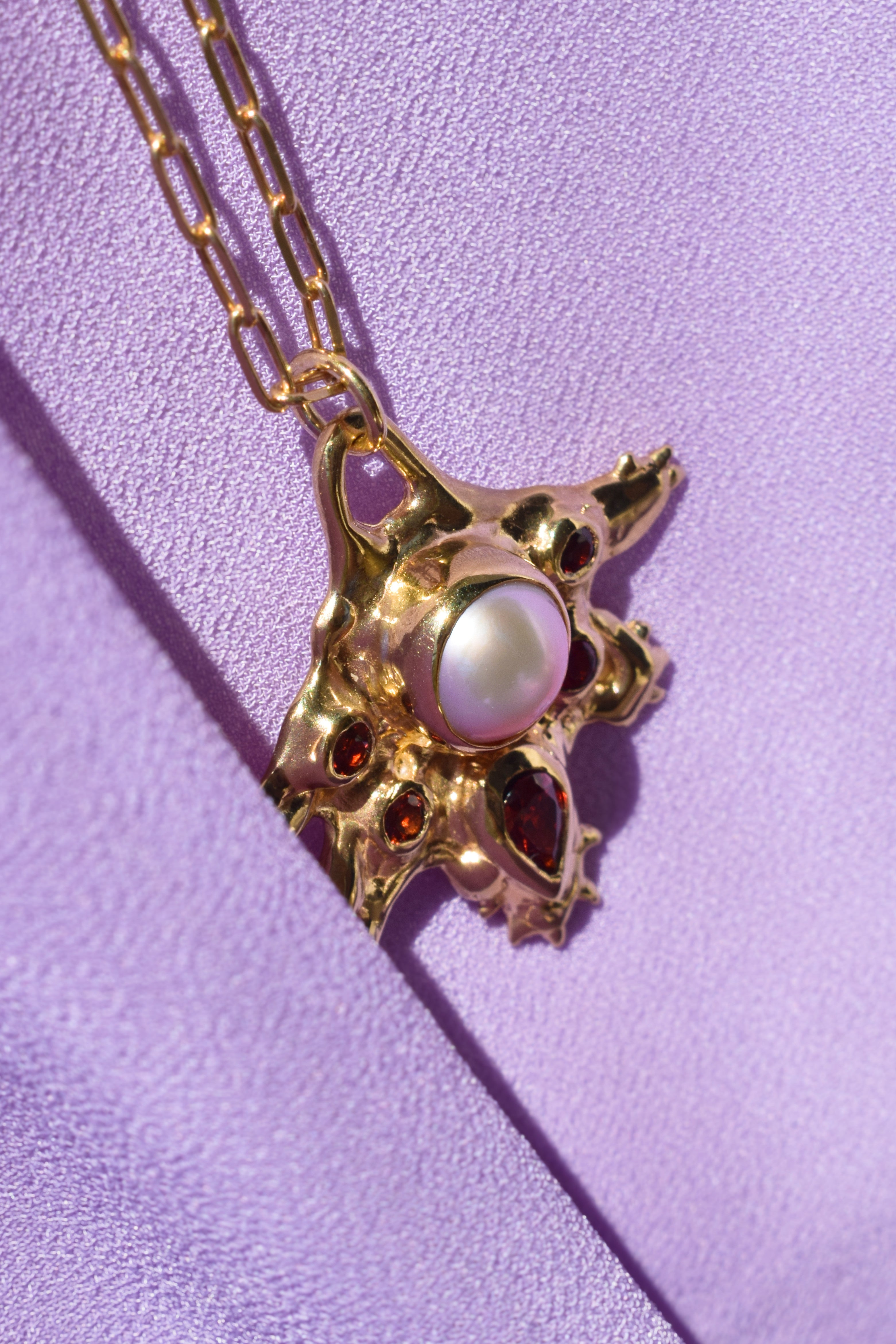 Coral inspired gold plated talisman necklace with pink pearl and red garnets