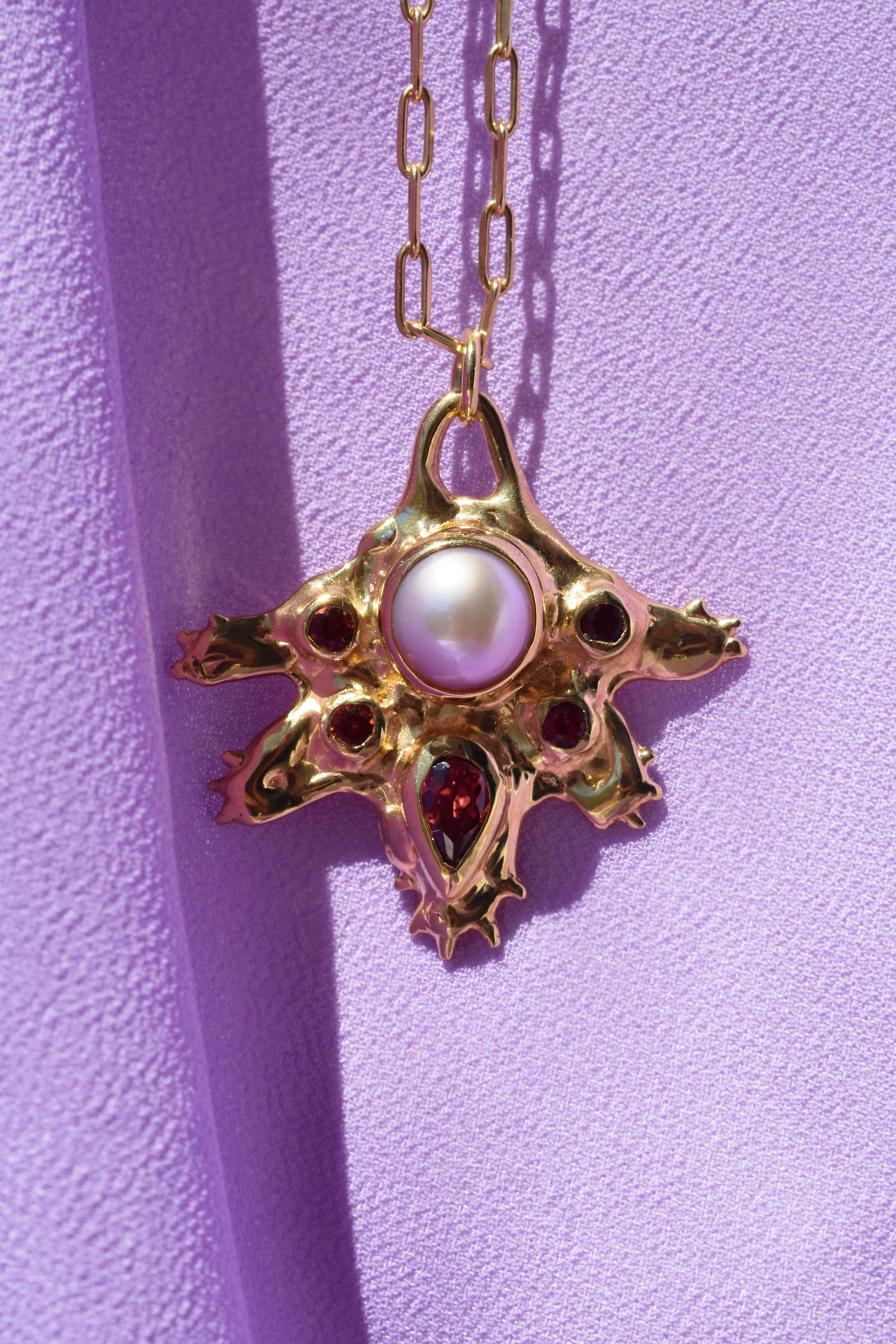 Coral inspired gold plated talisman necklace with pink pearl and red garnets