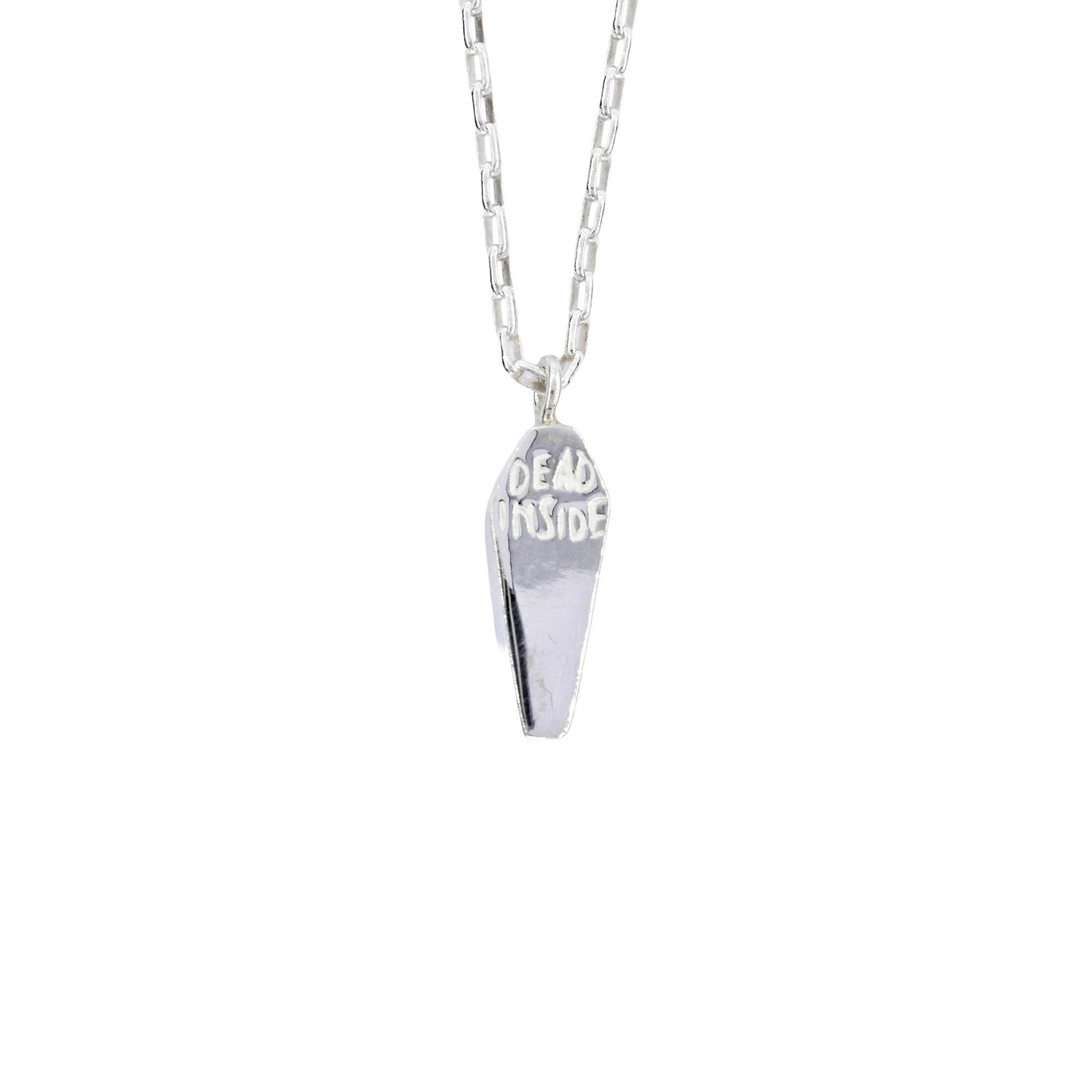 A silver coffin-shaped pendant necklace engraved with the words 'DEAD INSIDE' on a clean white background.