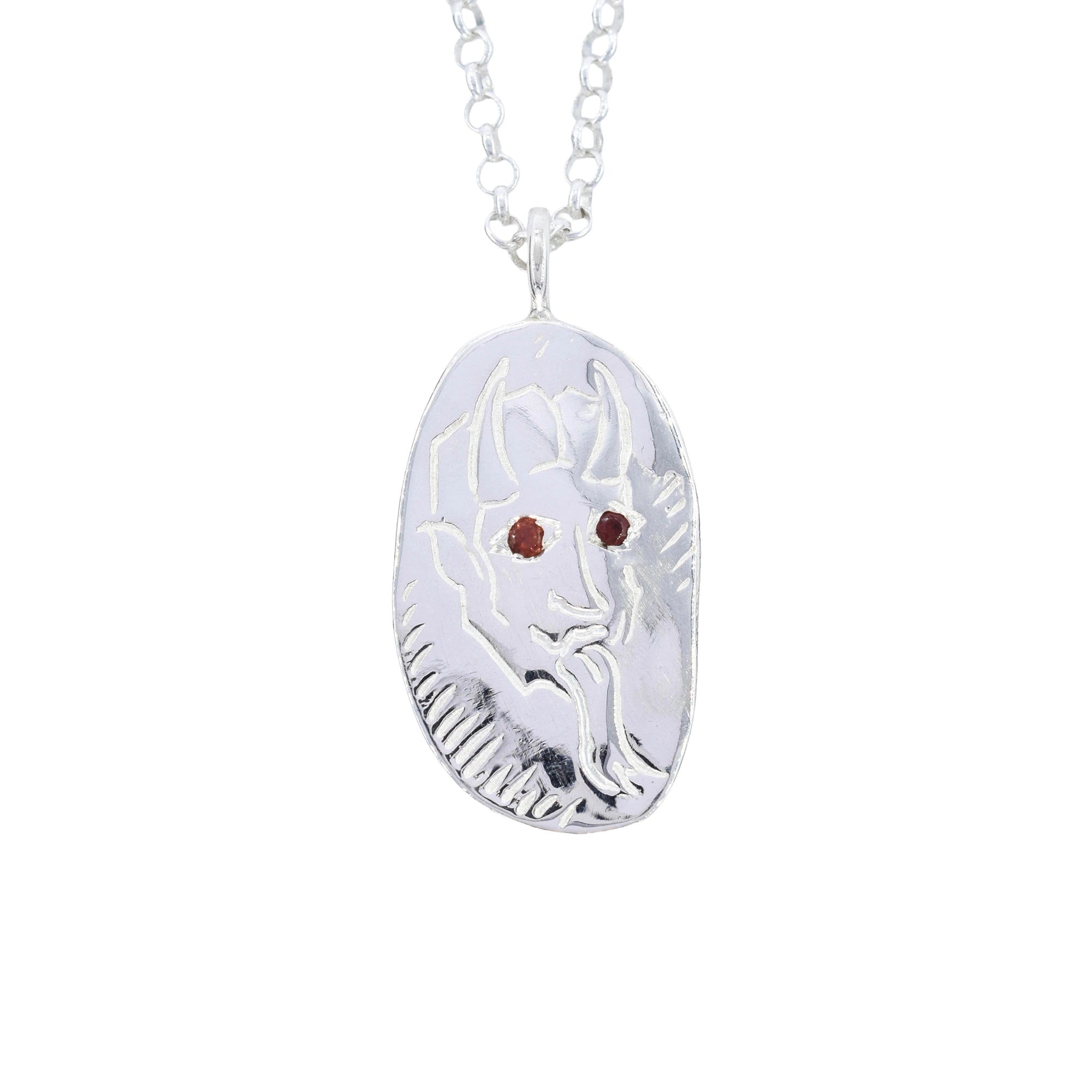 A silver pendant necklace featuring a stylized goat or ram head design with two small red gemstone eyes, shown on a white background.