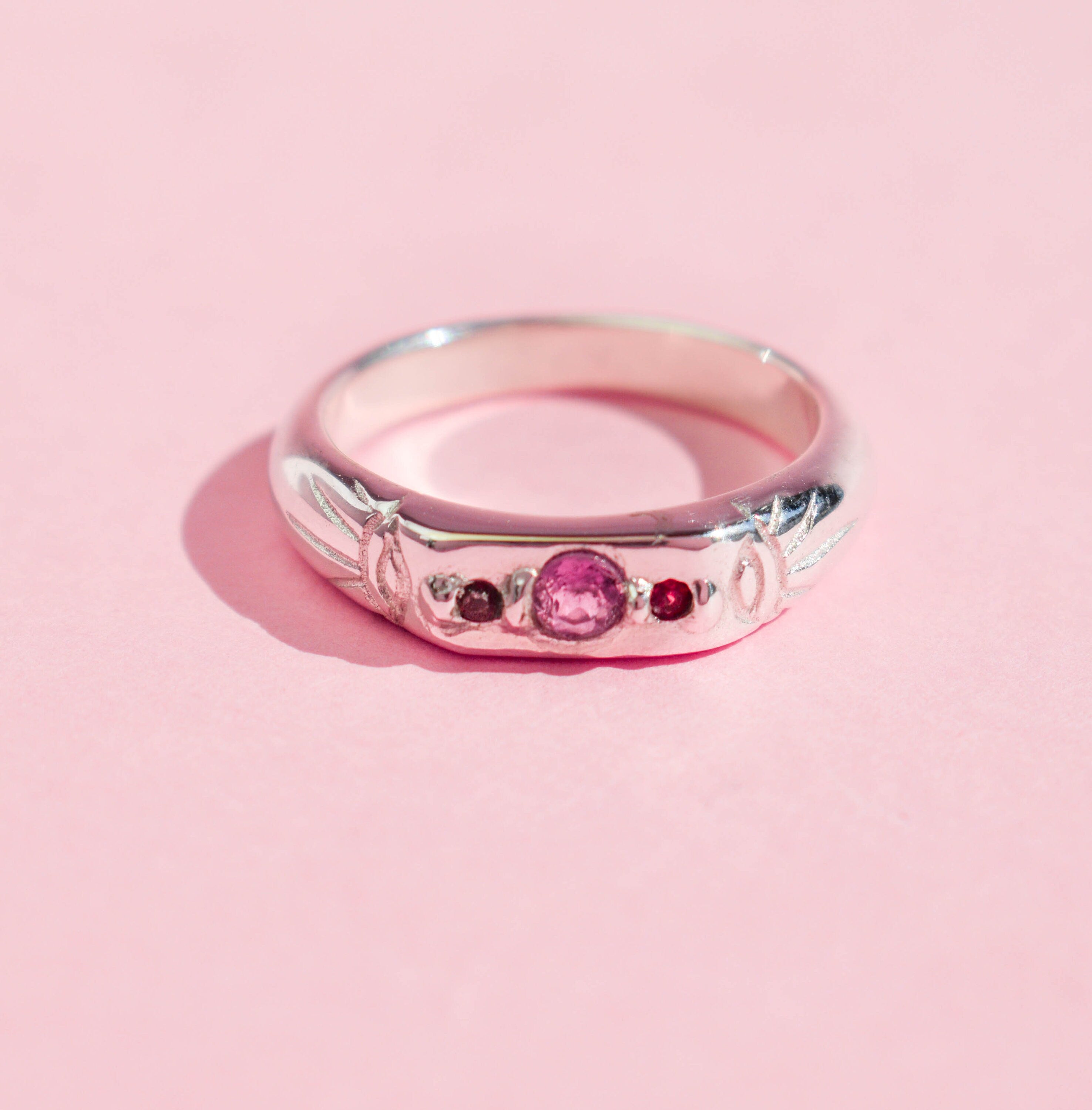Pink tourmaline and red garnet band ring with two evil eyes