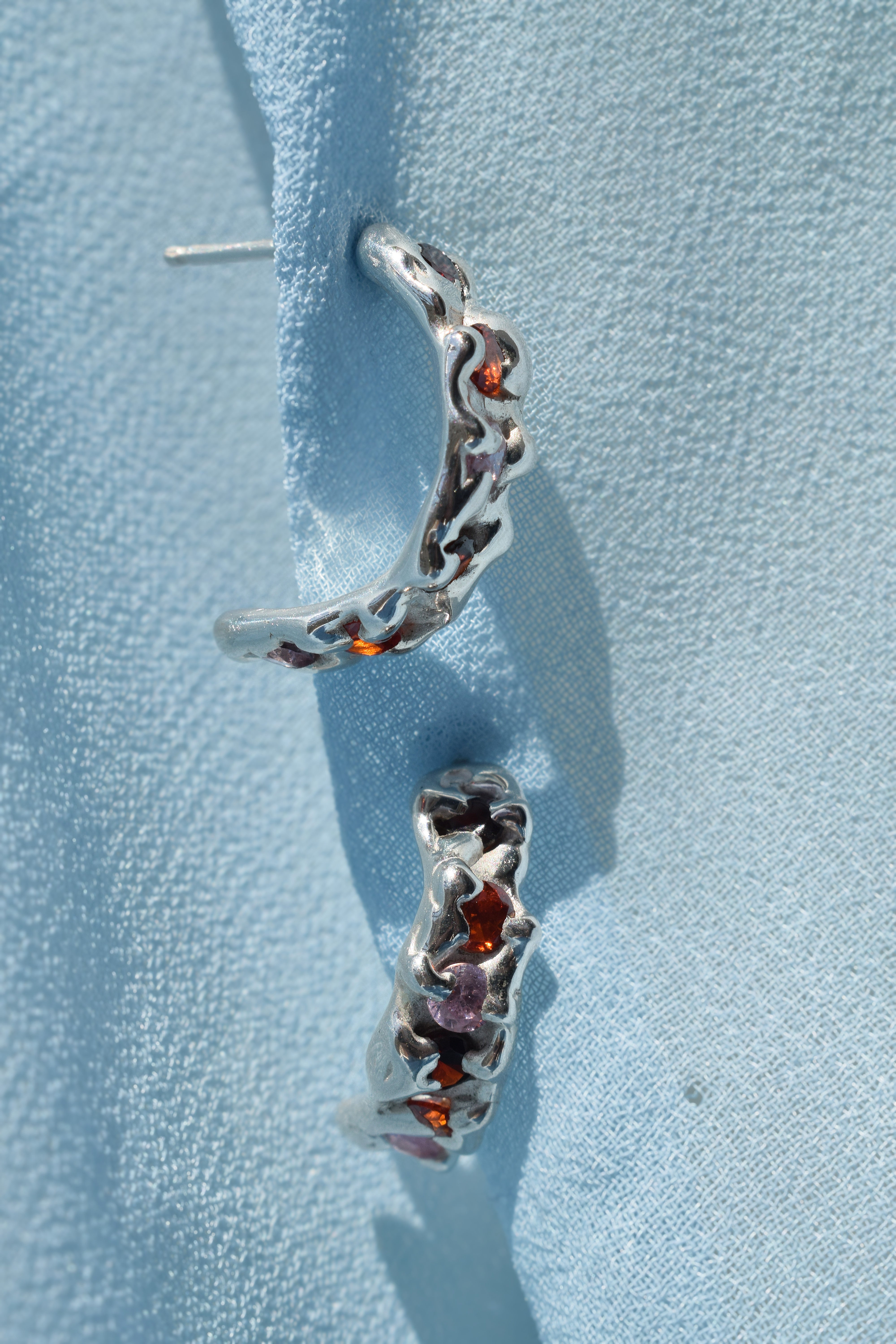 Sterling silver molten textured hoop earrings with red, orange & pink cz crystals