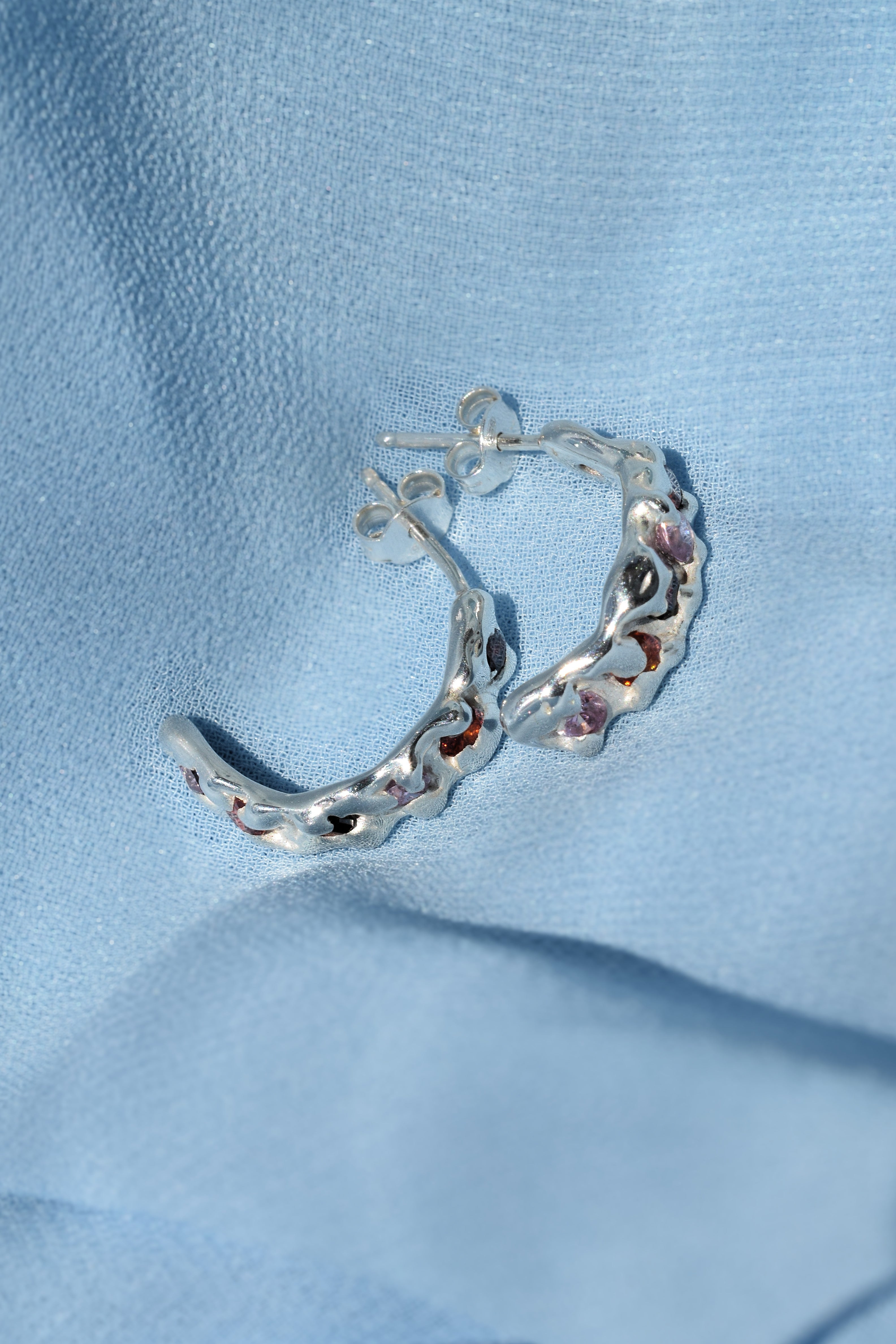 Sterling silver molten textured hoop earrings with red, orange & pink cz crystals