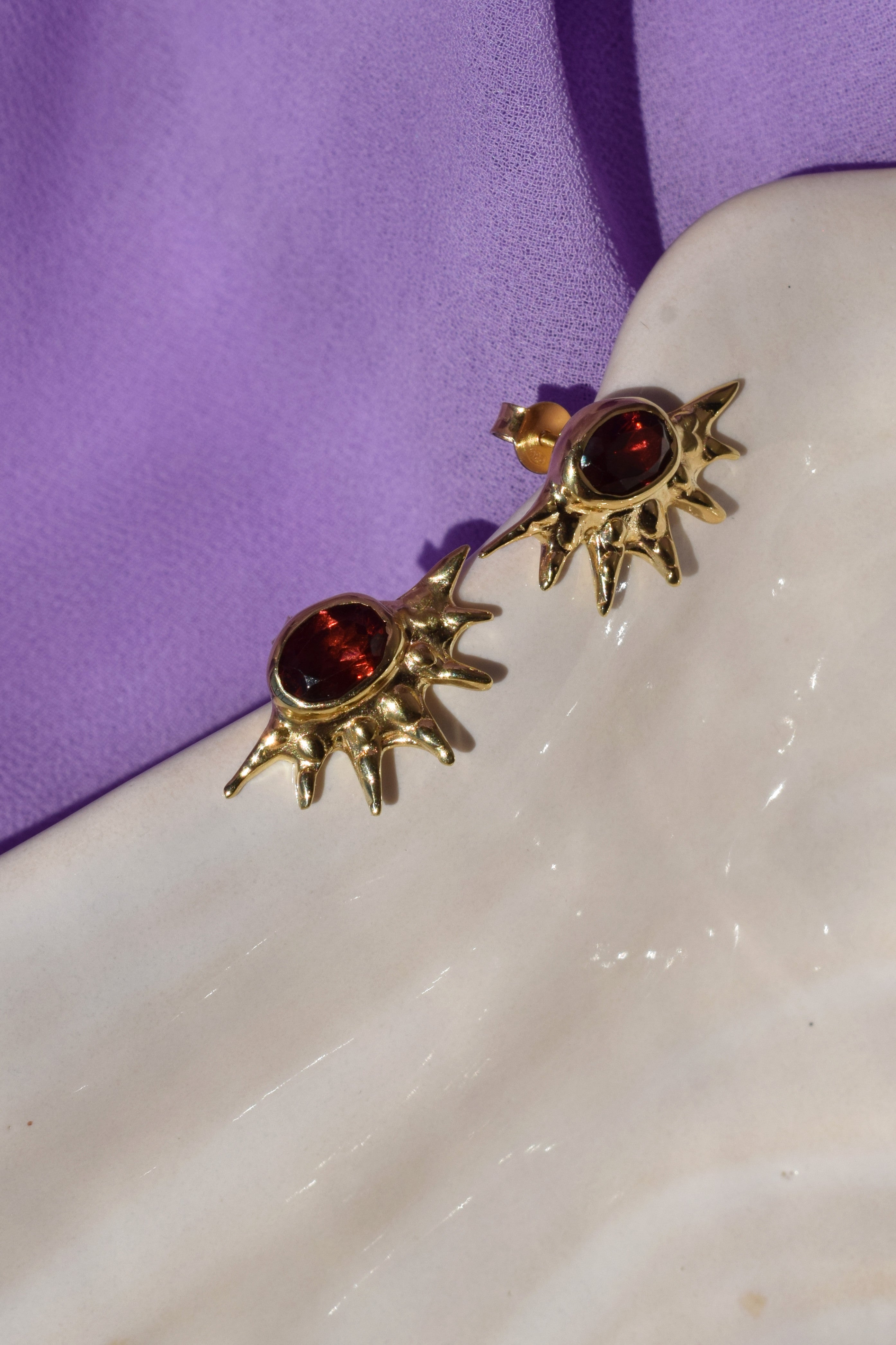 Sunburst stud earrings with red garnets