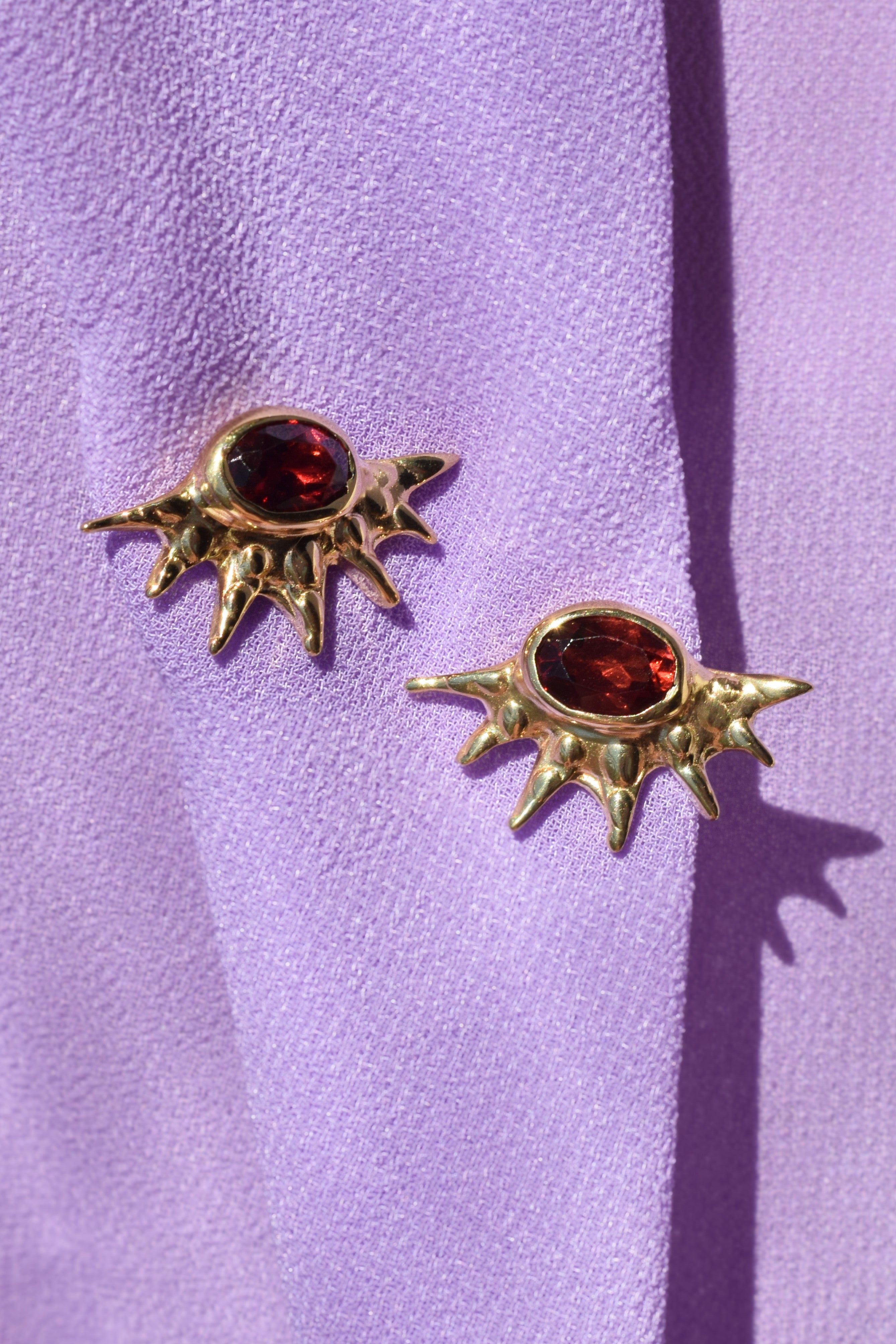 Sunburst stud earrings with red garnets