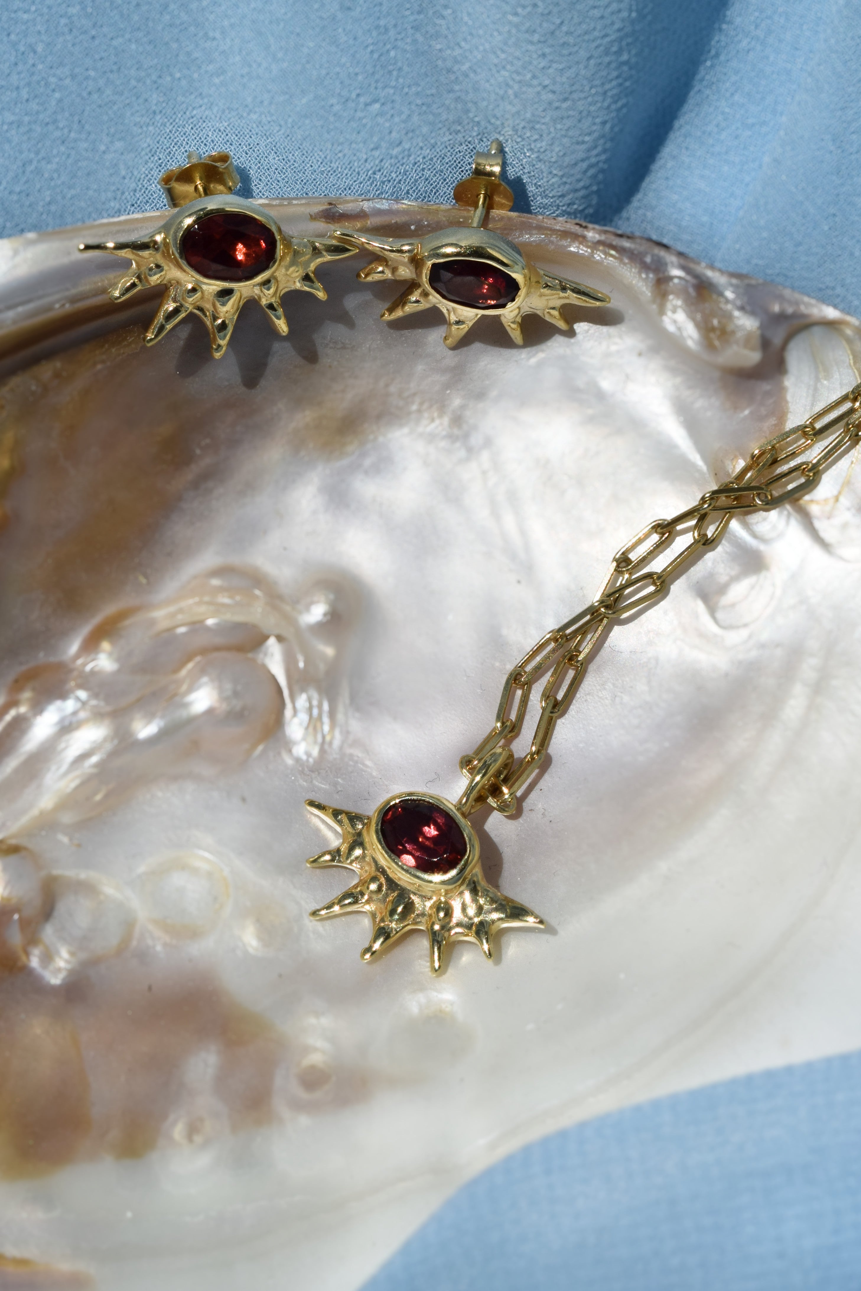 Sunburst stud earrings with red garnets