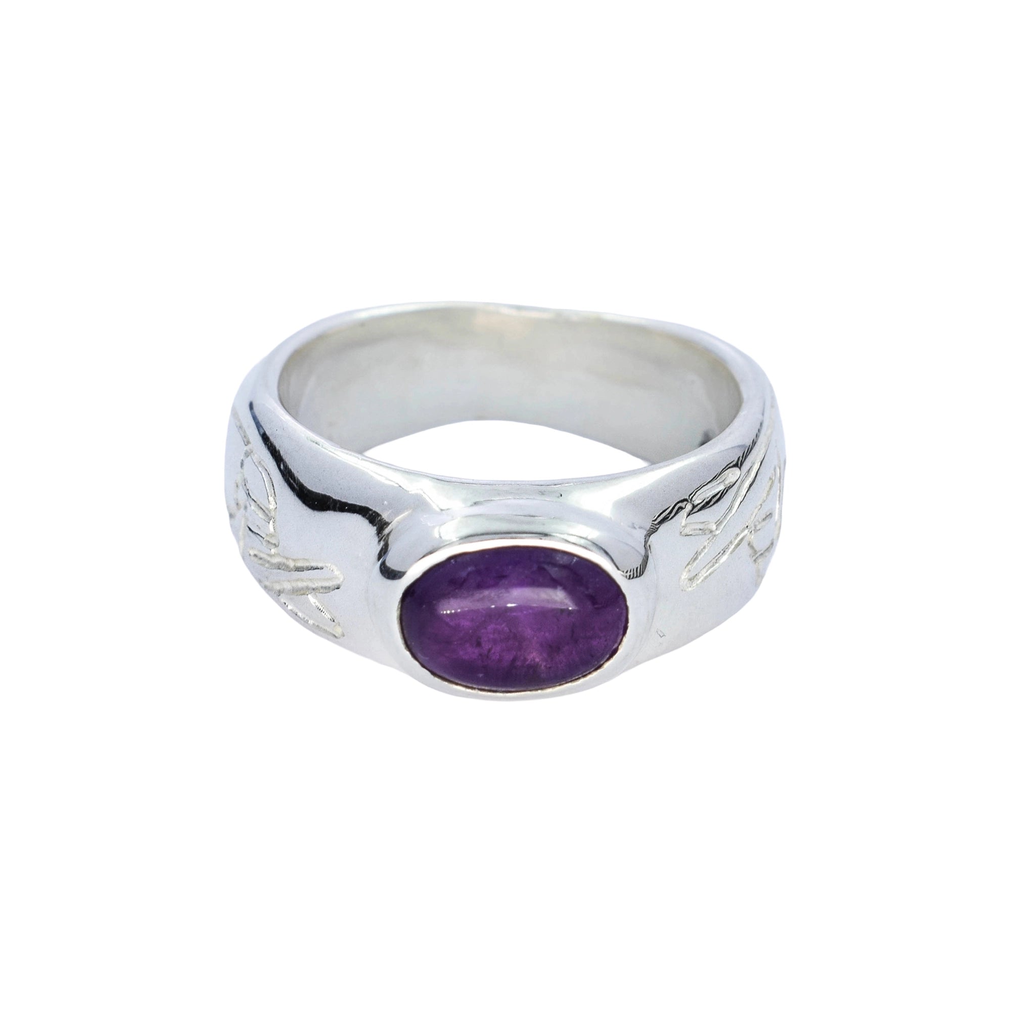 A sterling silver ring featuring a polished oval purple amethyst gemstone in the center, with engraved leaf-like patterns on the shoulders, set against a plain white background.