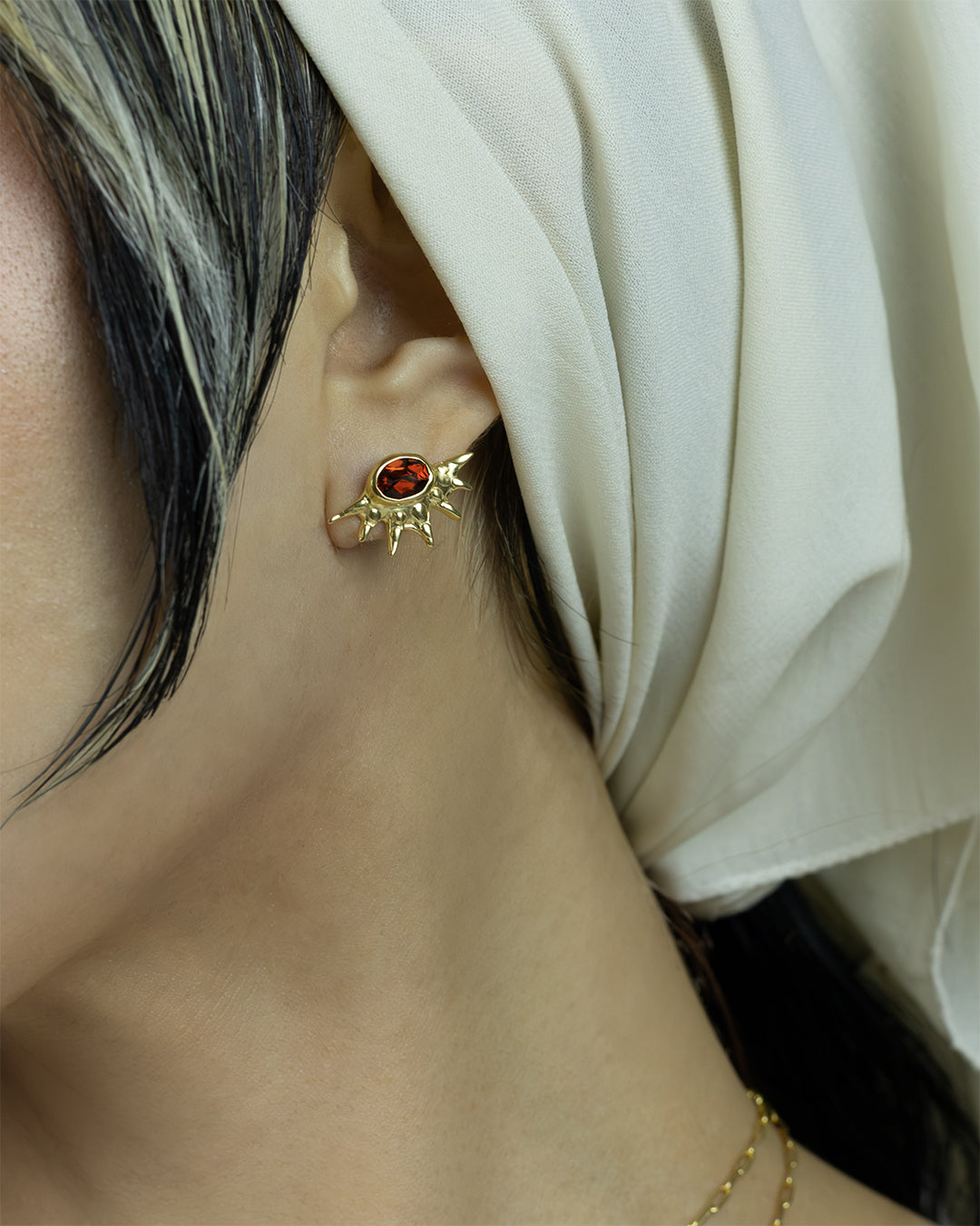 Sunburst stud earrings with red garnets