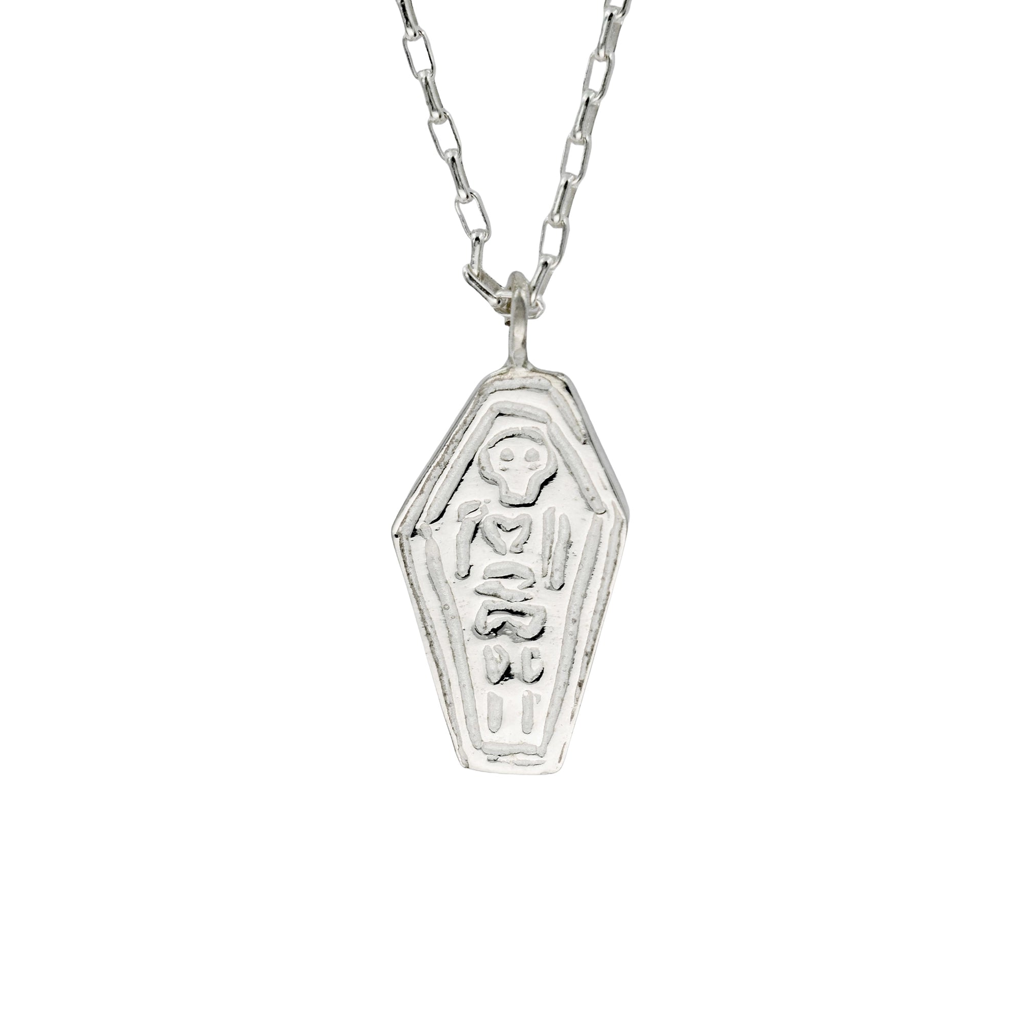 A silver coffin-shaped pendant necklace with engraved gothic-style lettering and a skull detail, suspended from a silver link chain against a plain white background.