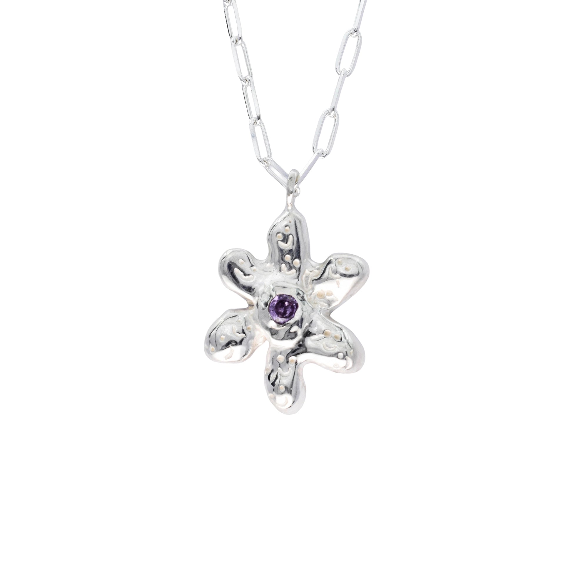 Silver flower-shaped pendant with a purple gemstone on a white chain against a white background