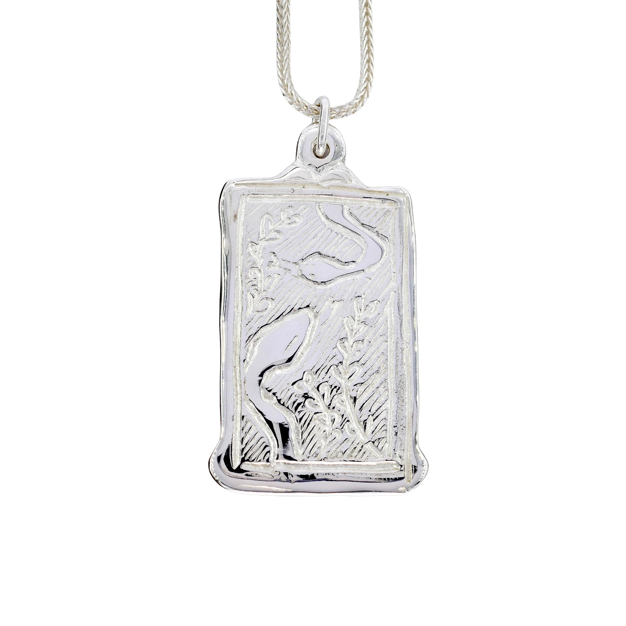 A silver rectangular pendant necklace featuring an engraved heron in a marsh scene, suspended from a silver chain against a plain white background.
