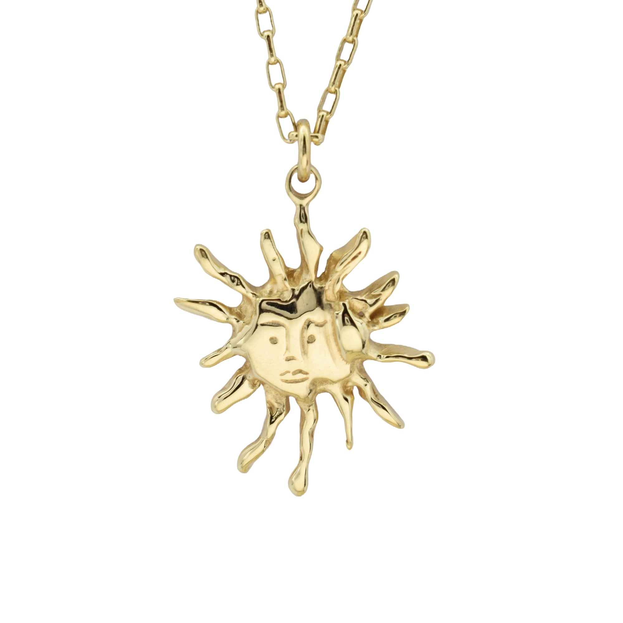 A gold pendant necklace featuring a stylized sun with a human face, suspended from a matching gold chain against a plain white background.