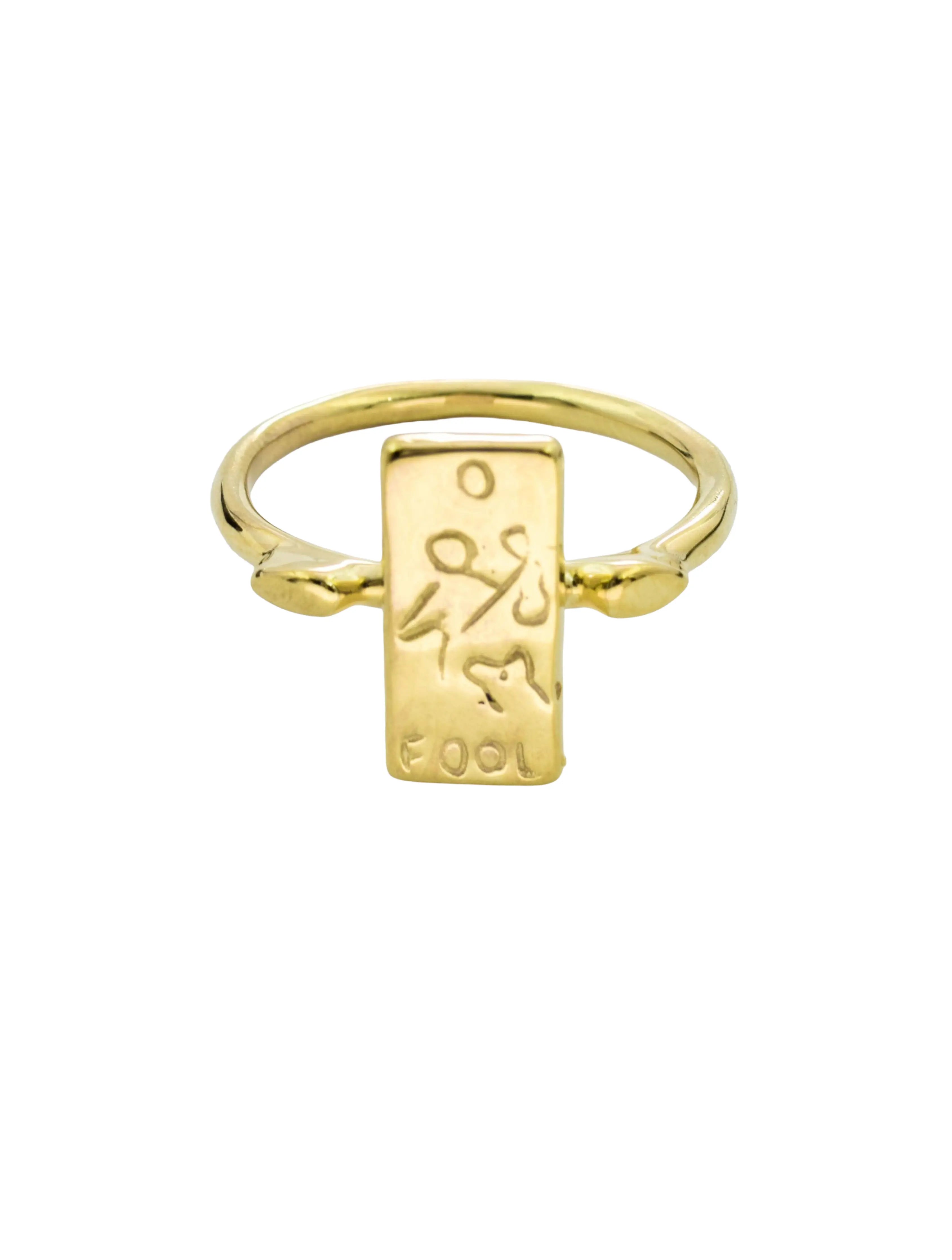 A gold-plated ring featuring a rectangular signet pendant engraved with a stylized figure and the word 'COOL'.