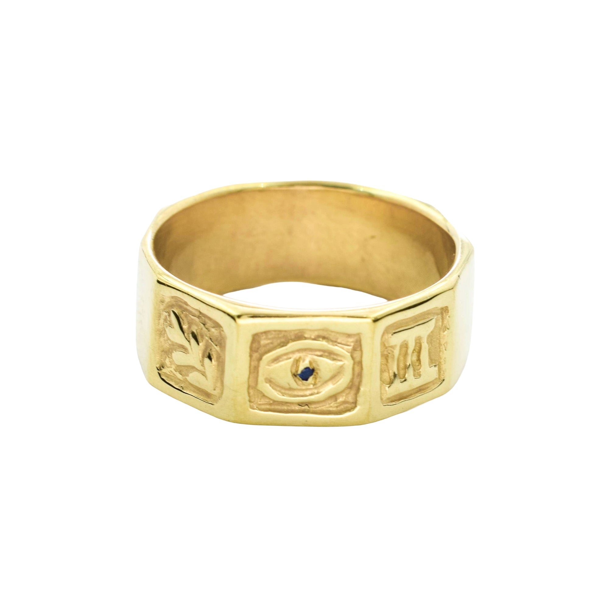 A gold signet-style ring with three raised geometric panels featuring engraved symbols and a small dark blue stone at the center of the middle panel, shown on a plain white background.