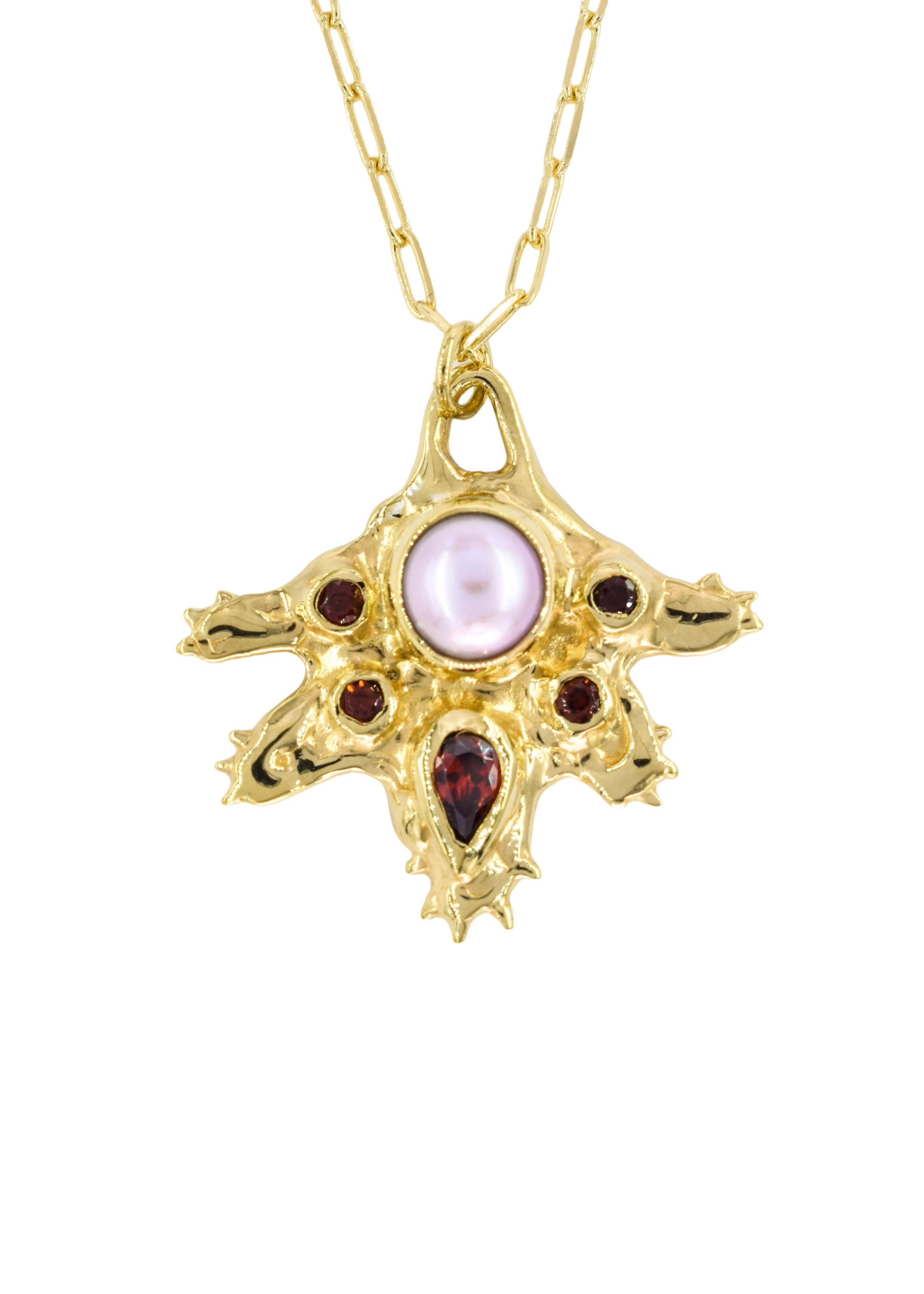 A gold pendant necklace featuring a spiky, starburst-like design with a central round pale pink pearl and three small dark red gemstones, shown on a white background.